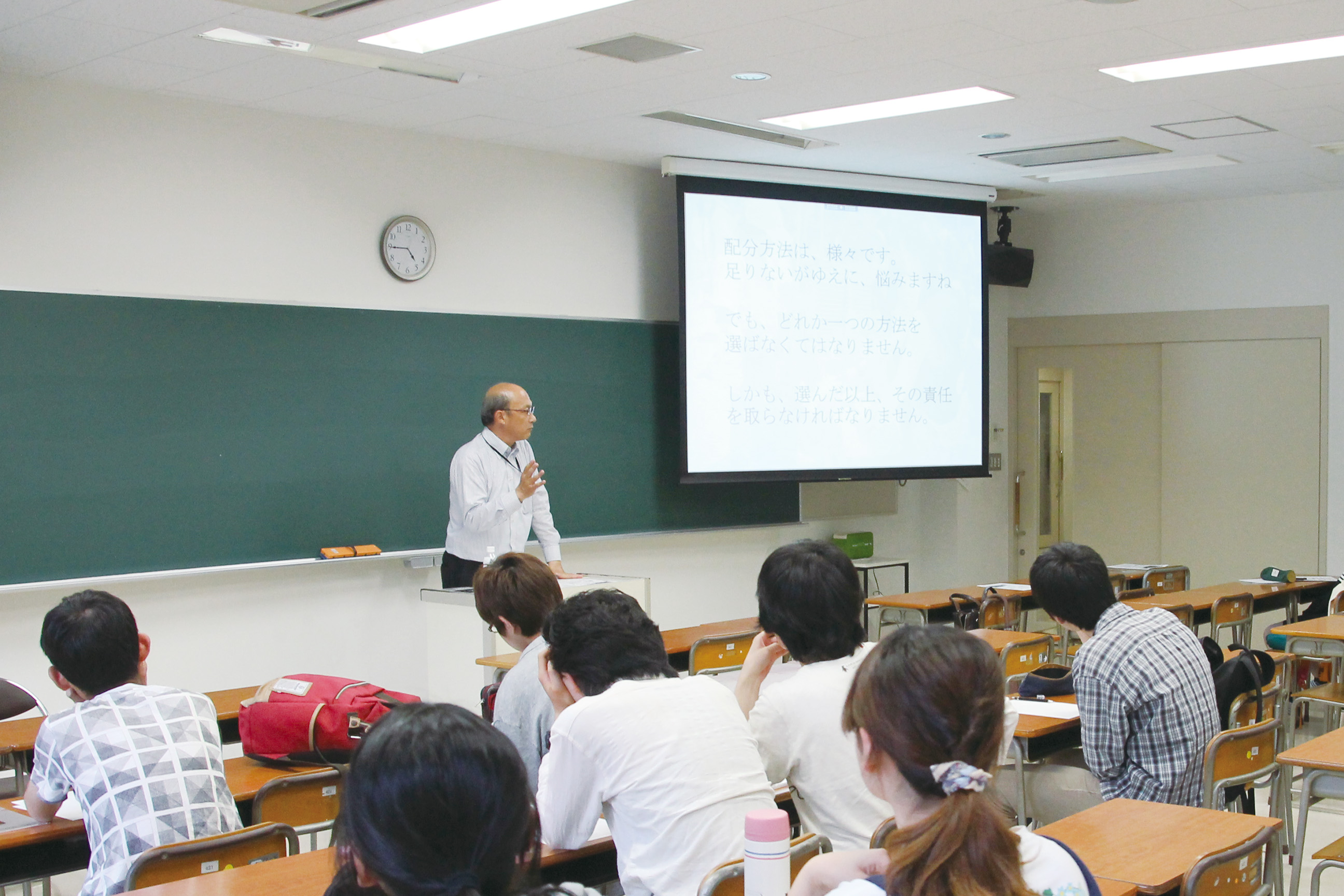 黒板の前で講義をしている様子